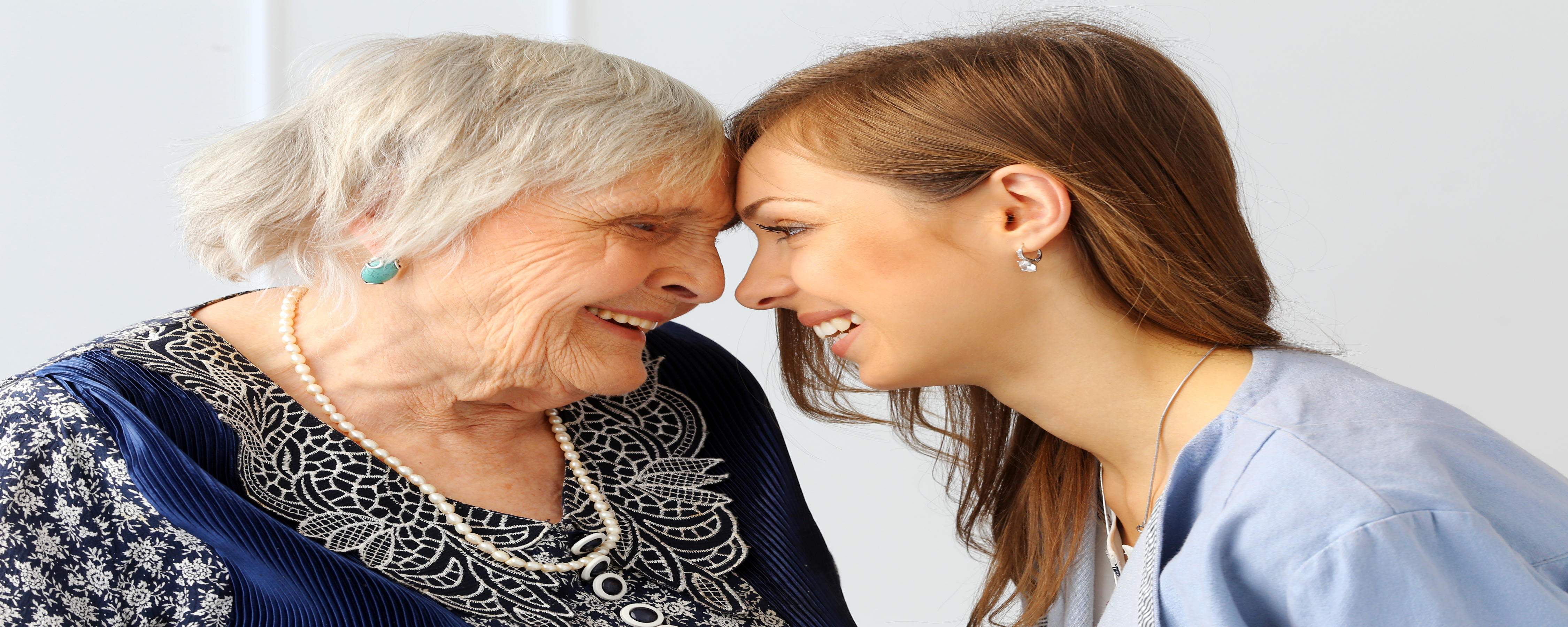 Aging adult and young person lovingly looking at each other